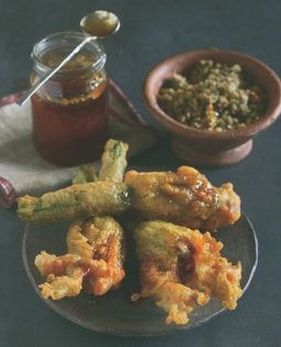 A deep-fried courgette flower stuffed with walnuts, garlic and bread, drizzled with honey