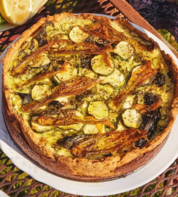 A very tall quiche with zucchini and greens