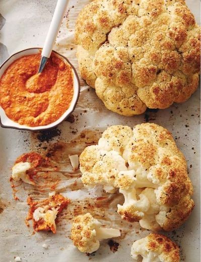 A whole head of roasted cauliflower with Romesco sauce