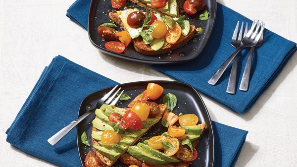 Avocado toast with cherry tomatoes, basil, cayenne, and olive oil