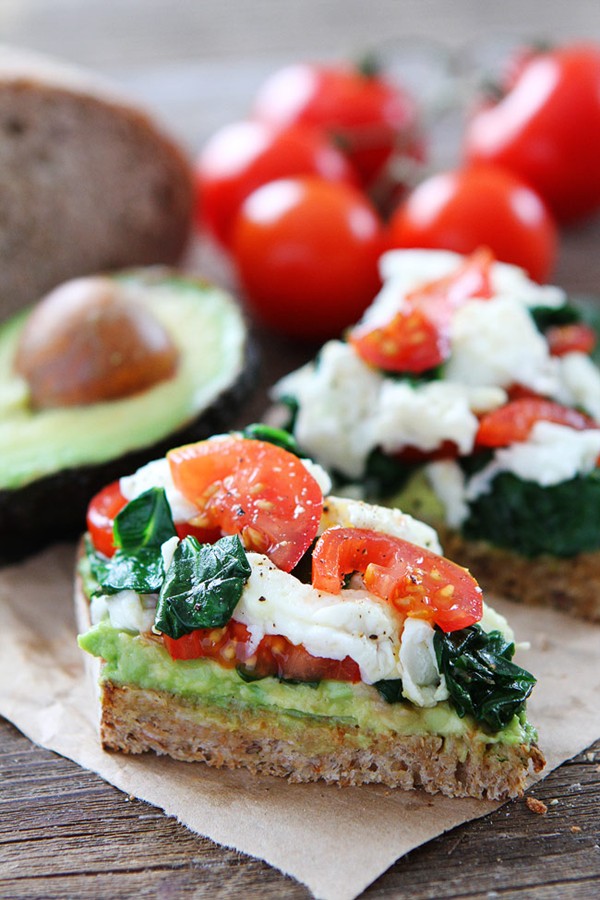 Avocado toast with eggs, spinach, and tomatoes