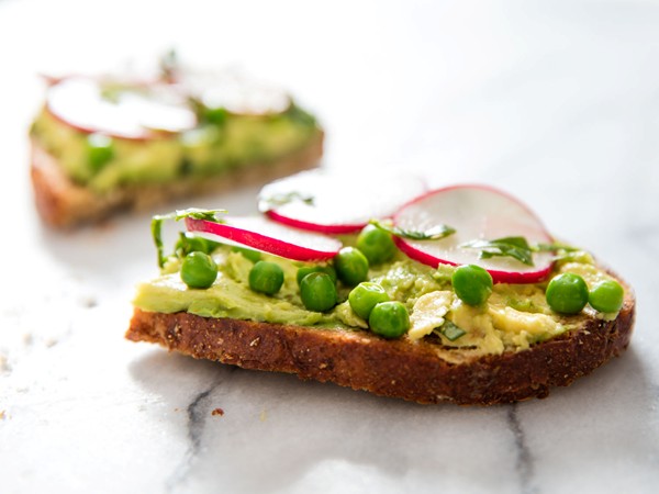 Avocado toast with radishes, baby peas, and fresh herbs
