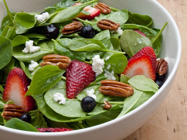 Baby spinach with fresh berries, pecans and goat cheese in raspberry vinaigrette