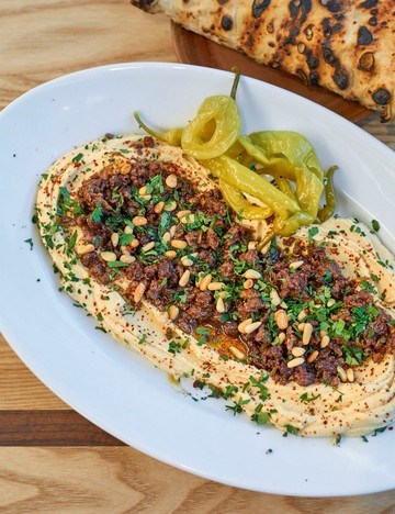 Baharat-spiced lamb, hummus, pine nuts, raisins and flatbreads