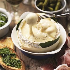 Baked cheese in a box with herb pesto