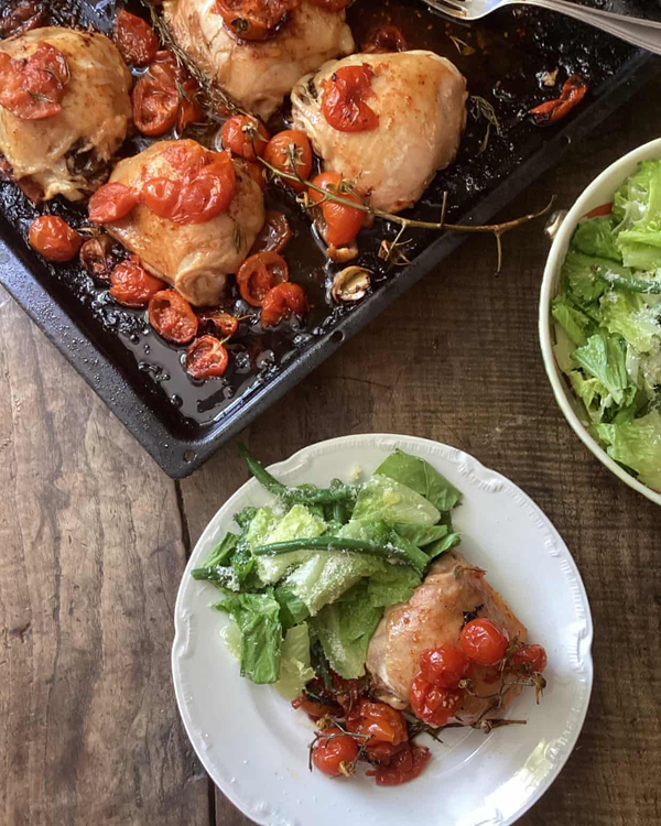 Baked chicken thighs with tomatoes, and a green bean, lettuce and Parmesan salad