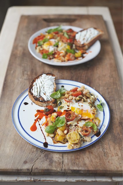 Baked eggs in popped beans and cherry tomatoes with ricotta on toast