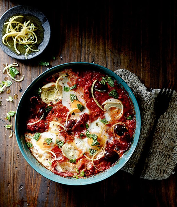 Baked eggs with artichoke, salami, tomato, olives and mint
