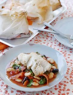 Baked fish in a bag with tomatoes, butter beans and chorizo