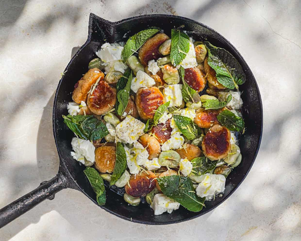 Baked potato gnocchi with broad beans, pecorino and milk