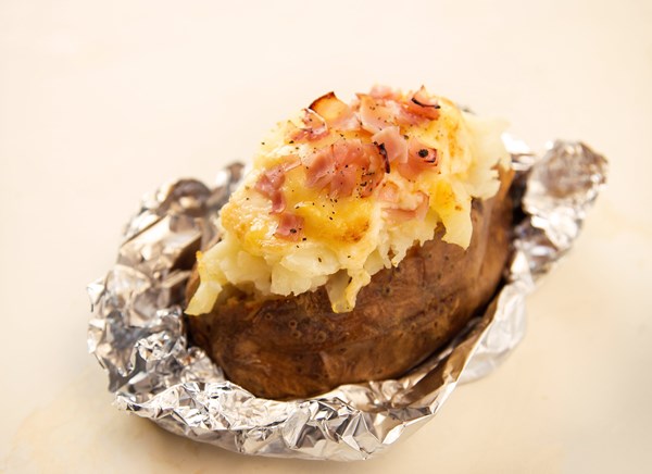 Baked potato stuffed with ham and melted Gruyère 