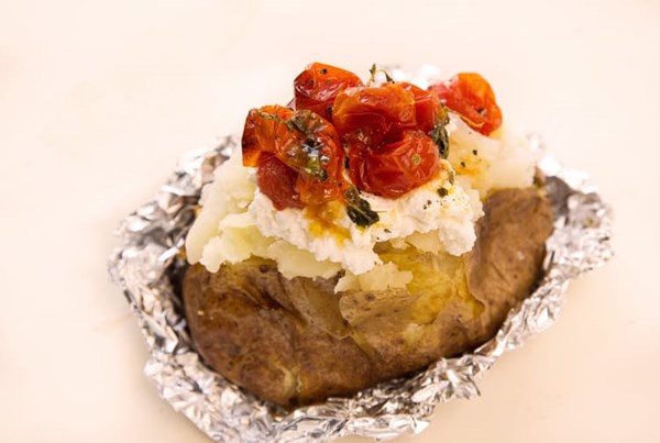 Baked potato stuffed with ricotta and roasted tomatoes