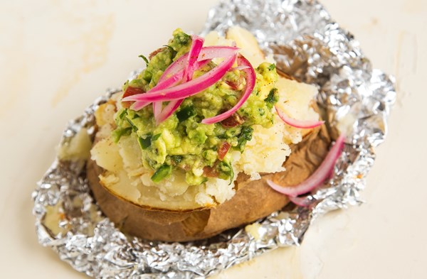 Baked potato with guacamole and pickled red onions