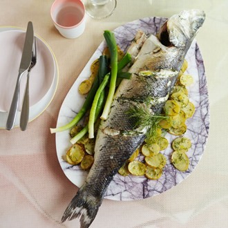 Baked sea bass with baby leeks, potatoes, raki and dill