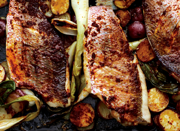 Baked snapper with harissa, new potatoes, and spring onions
