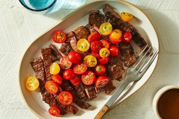 Balsamic vinaigrette-marinated skirt steak with tomato salad