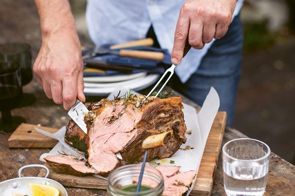 Barbecued lamb leg on a brick with chimichurri