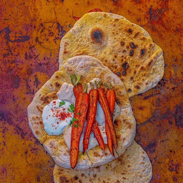 Barbecued new-season carrots with cumin, chilli, orange zest and rosemary, and flatbreads with white bean hummus