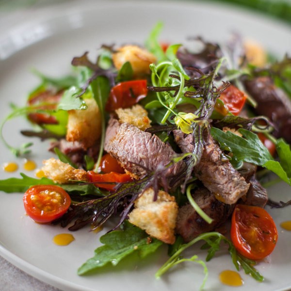 Barbecued steak salad with cherry tomato vinaigrette, crunchy bread and greens