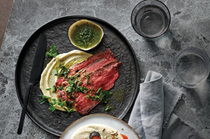 Beef striploin with confit garlic paste and green sauce