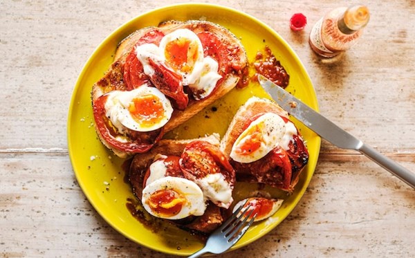Big toast with roast tomatoes, jammy eggs, mayo and hot sauce