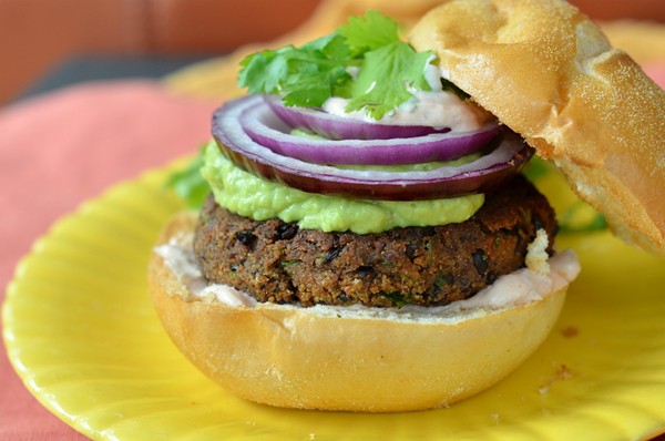 Black bean burgers with red onion, guacamole, and creamy salsa