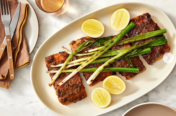 Black garlic-marinated grilled salmon with charred scallions