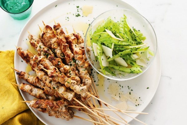 Black pepper-marinated chicken skewers with celery, Parmesan, & preserved lemon salad
