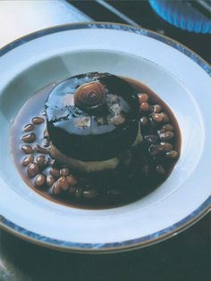 Black pudding on crushed potatoes and baked beans with bay leaf sauce