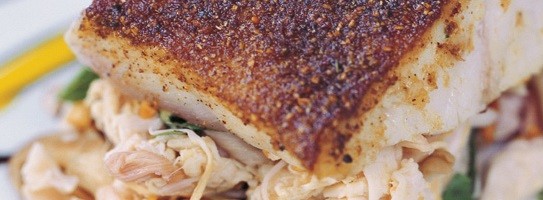 Blackened barramundi on braised banana blossoms with a turmeric balsamic vinaigrette (Cá vược ap chảo với hoa chuối om)