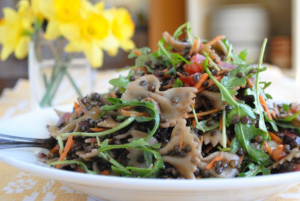 Bowtie, lentil, and arugula salad with tomatoes and red onion
