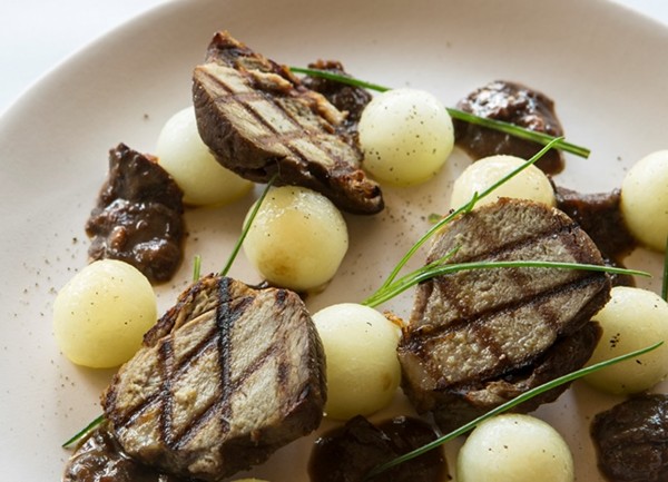 Braised and grilled lamb shanks with prunes and melon
