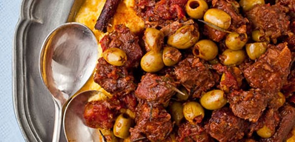 Braised pork shoulder with tomatoes, cinnamon, and olives over polenta