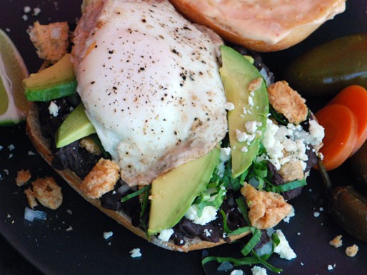 Breakfast torta (Mexican breakfast sandwich with eggs, crispy pork, and beans)
