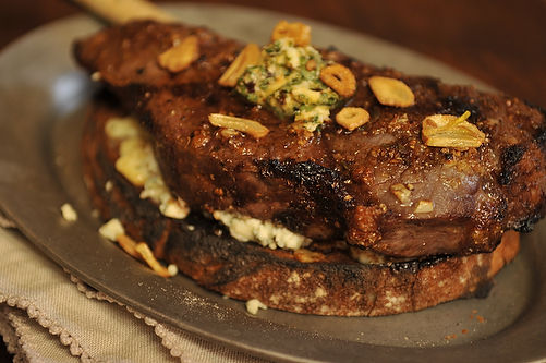 Broiled spicy steak with garlic chips on Gorgonzola crostini