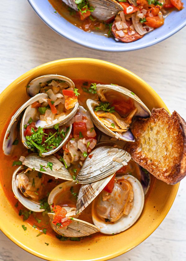 Brothy clams with chorizo, tomatoes, and grilled bread