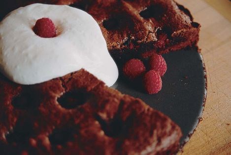 Brownie cake poked with red raspberries