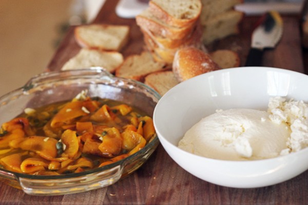 Bruschetta with homemade ricotta, roasted yellow peppers, and green garlic