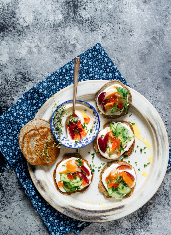 Buckwheat blinis with smoked trout, crème fraîche, fish roe & grapes