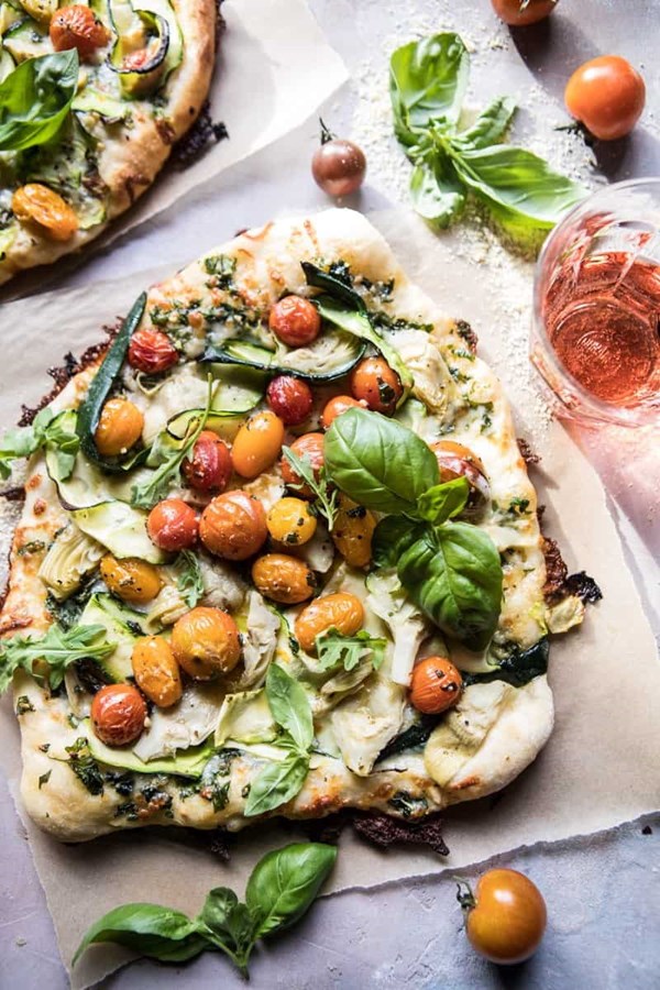 Burst cherry tomato, artichoke, and zucchini pesto pizza