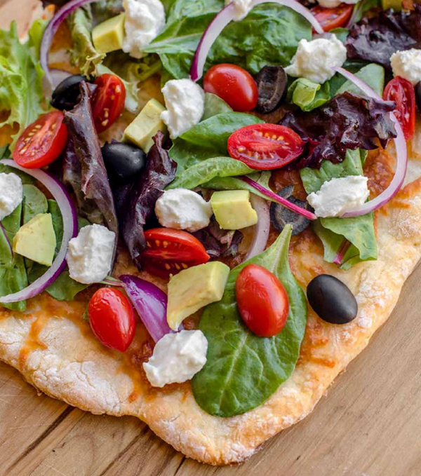 California pizza with fresh greens, olives and avocado