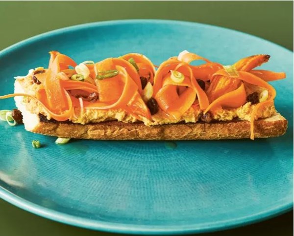 Carrot hummus with raisin & pickle on baguette