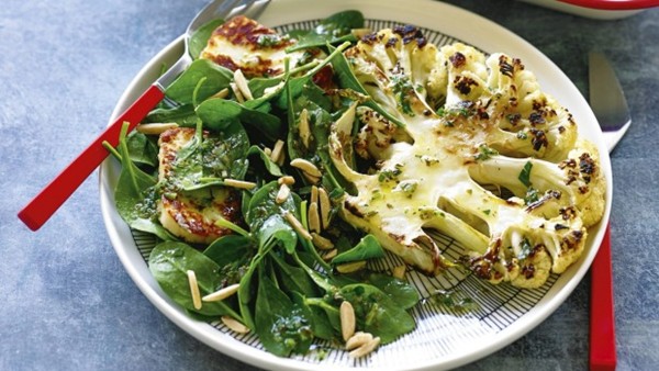 Cauliflower steaks with haloumi, spinach and almond salad