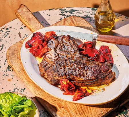 Chargrilled grilled T-bone steak with confit Piquillo peppers