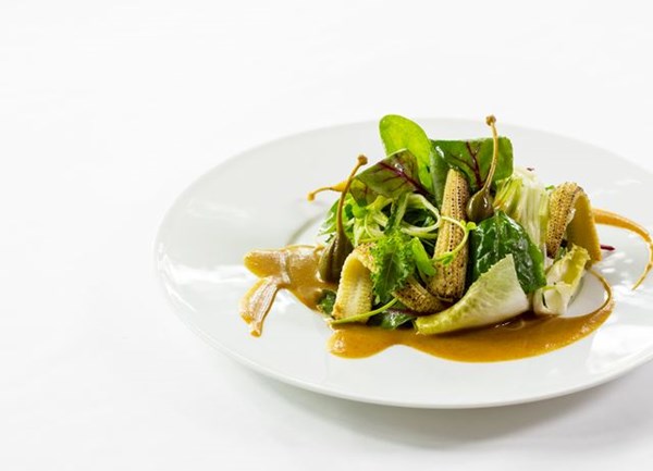 Charred baby corn salad with prunes and mustard