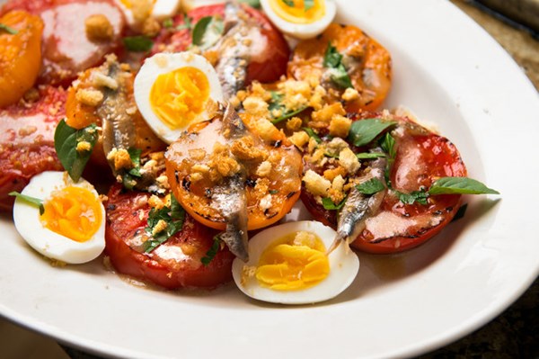 Charred tomatoes with egg, anchovies and bread crumbs