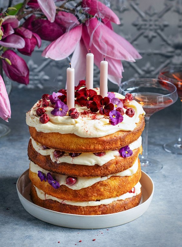 Cherry almond layer cake topped with cherries and flowers