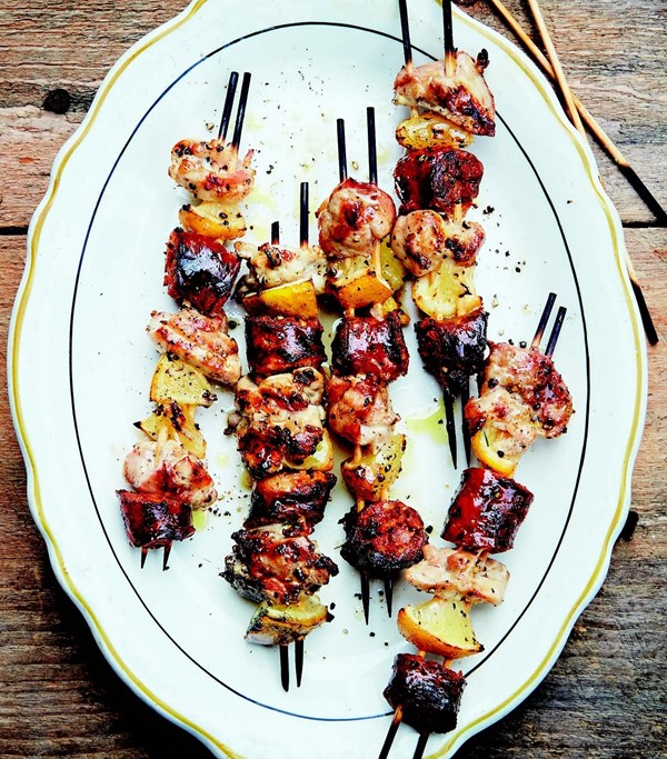 Chicken skewers with Italian sausage and lemon wedges