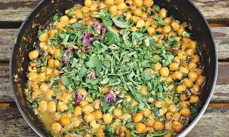 Chickpea stew with wet garlic, sage flowers and broad bean tops