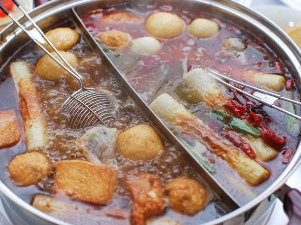 Chinese-style hot pot with rich broth, shrimp balls, and dipping sauces